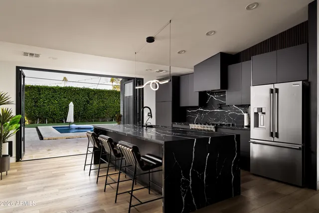 a kitchen with stainless steel appliances granite countertop a sink stove and refrigerator