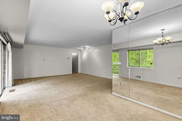 an empty room with windows and chandelier