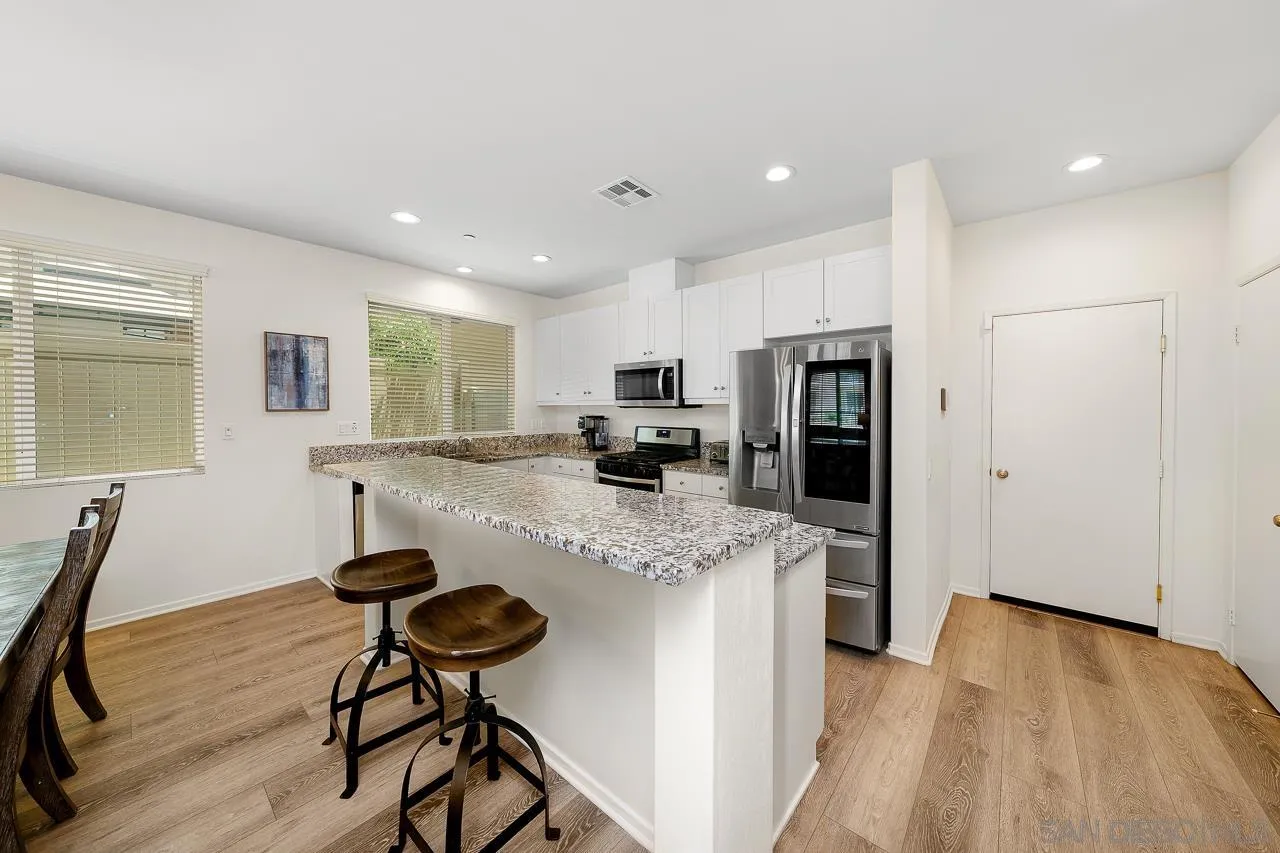 1290 Santa Victoria Road, Unit 2 Chula Vista, CA 91913 - Photo 11 of 41 a kitchen with granite countertop a counter space dining table and stainless steel appliances