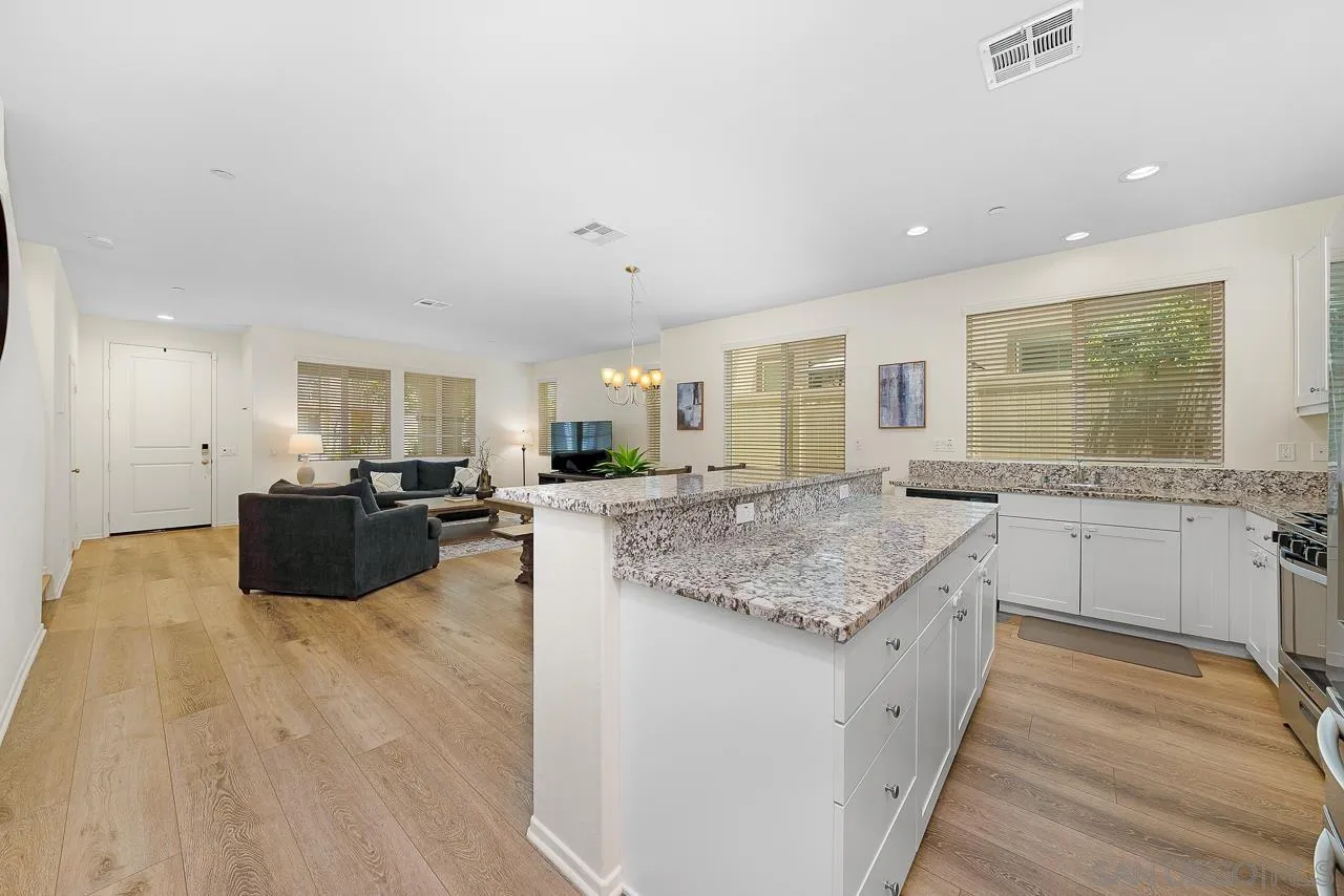 1290 Santa Victoria Road, Unit 2 Chula Vista, CA 91913 - Photo 12 of 41 a kitchen with stainless steel appliances granite countertop a lot of counter space and wooden floor