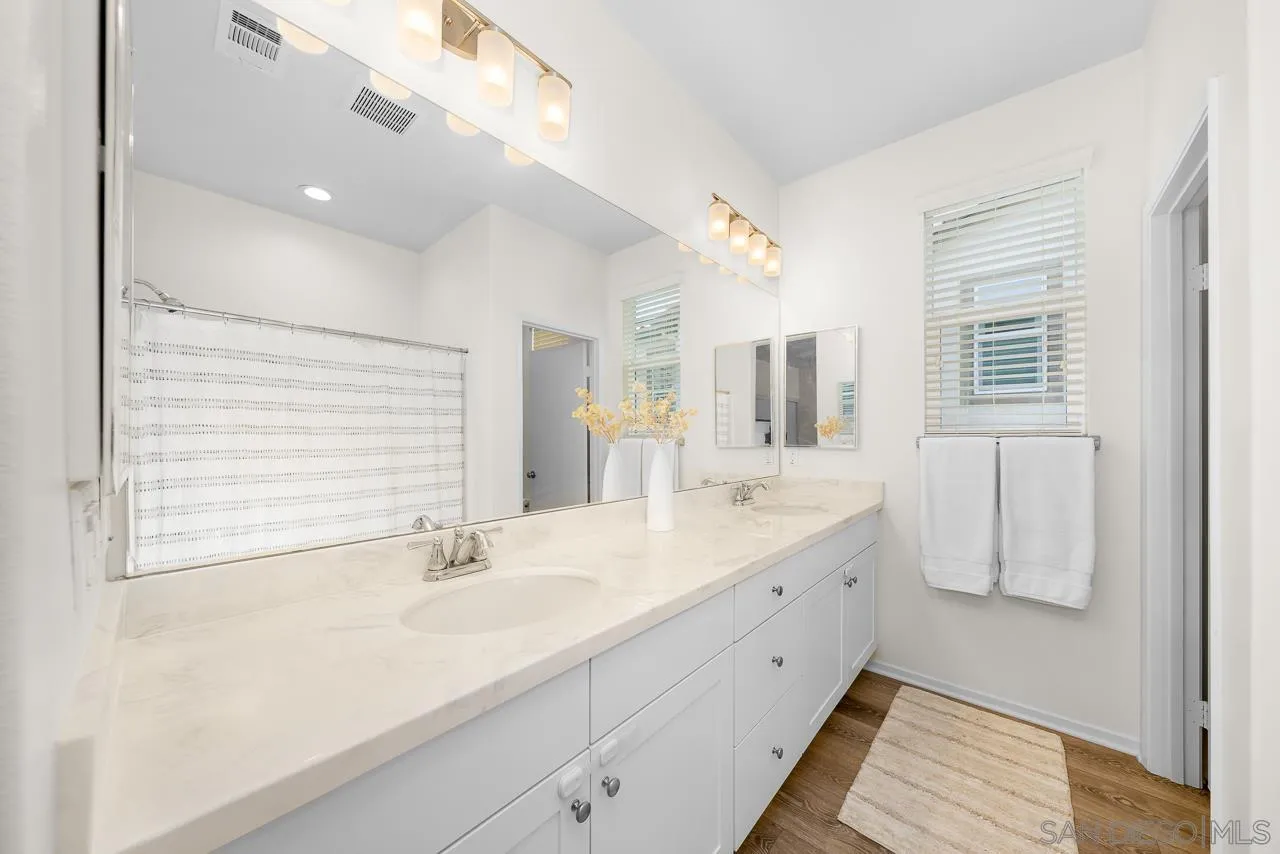 1290 Santa Victoria Road, Unit 2 Chula Vista, CA 91913 - Photo 24 of 41 a bathroom with a double vanity sink a mirror and a shower