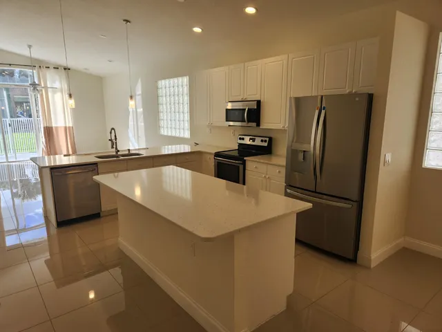 a kitchen with stainless steel appliances a refrigerator stove microwave and sink