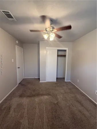 a view of a big room with chandelier fan and windows