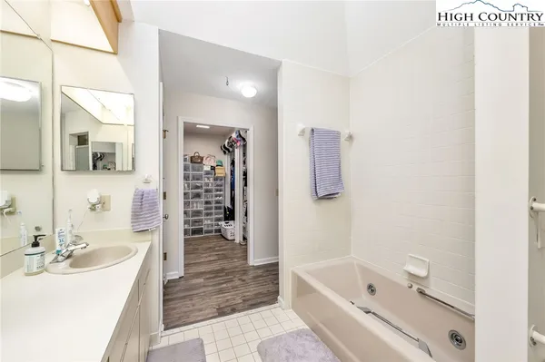 a bathroom with a tub a sink and a large mirror