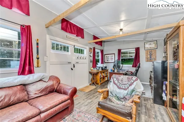 a living room with furniture a flat screen tv and a large window
