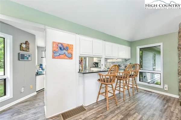 a kitchen with stainless steel appliances wooden floors and table