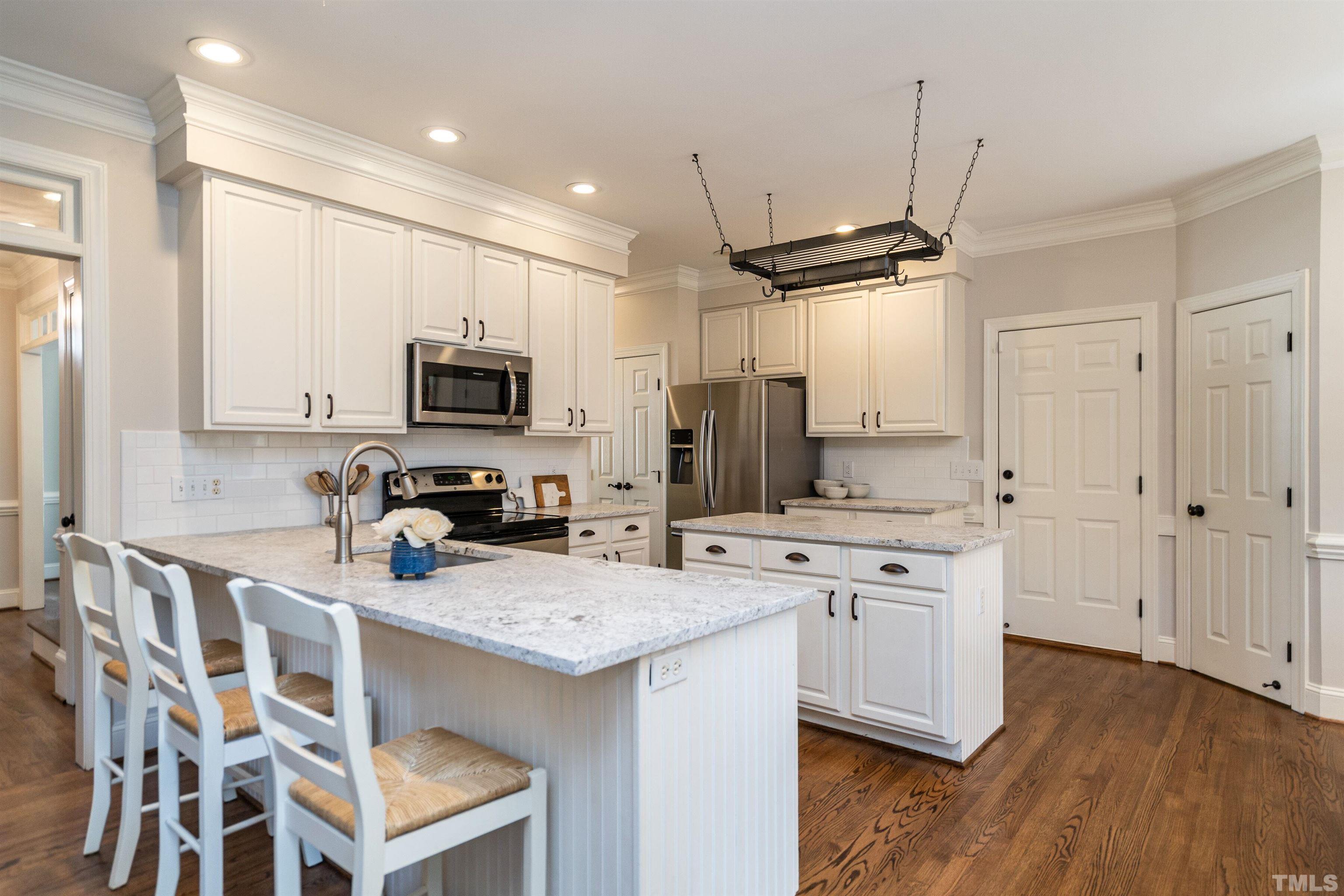3016 Stone Gap Court Raleigh, NC 27612 - Photo 13 of 37 a kitchen with a sink stainless steel appliances and wooden floor
