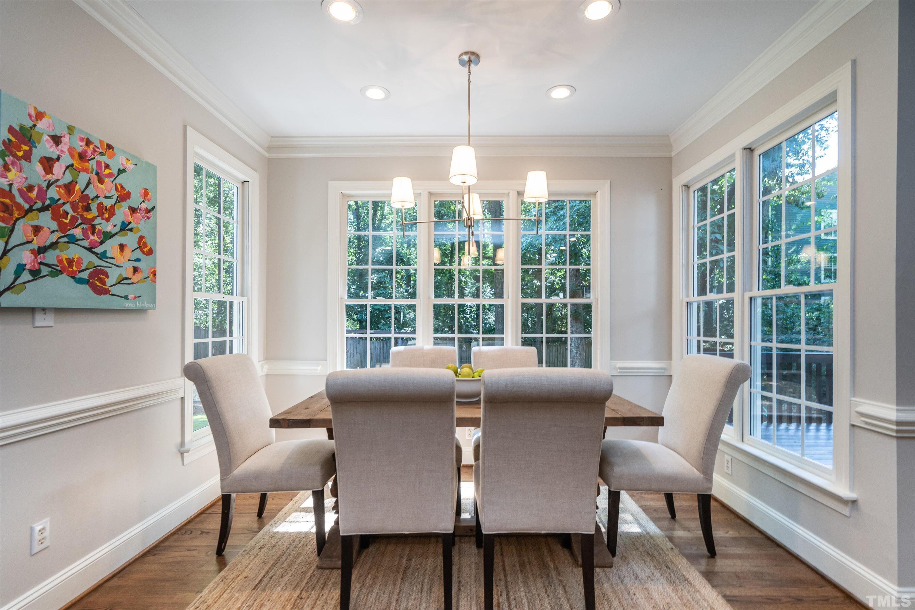 3016 Stone Gap Court Raleigh, NC 27612 - Photo 17 of 37 a view of a dining room with furniture a chandelier and wooden floor