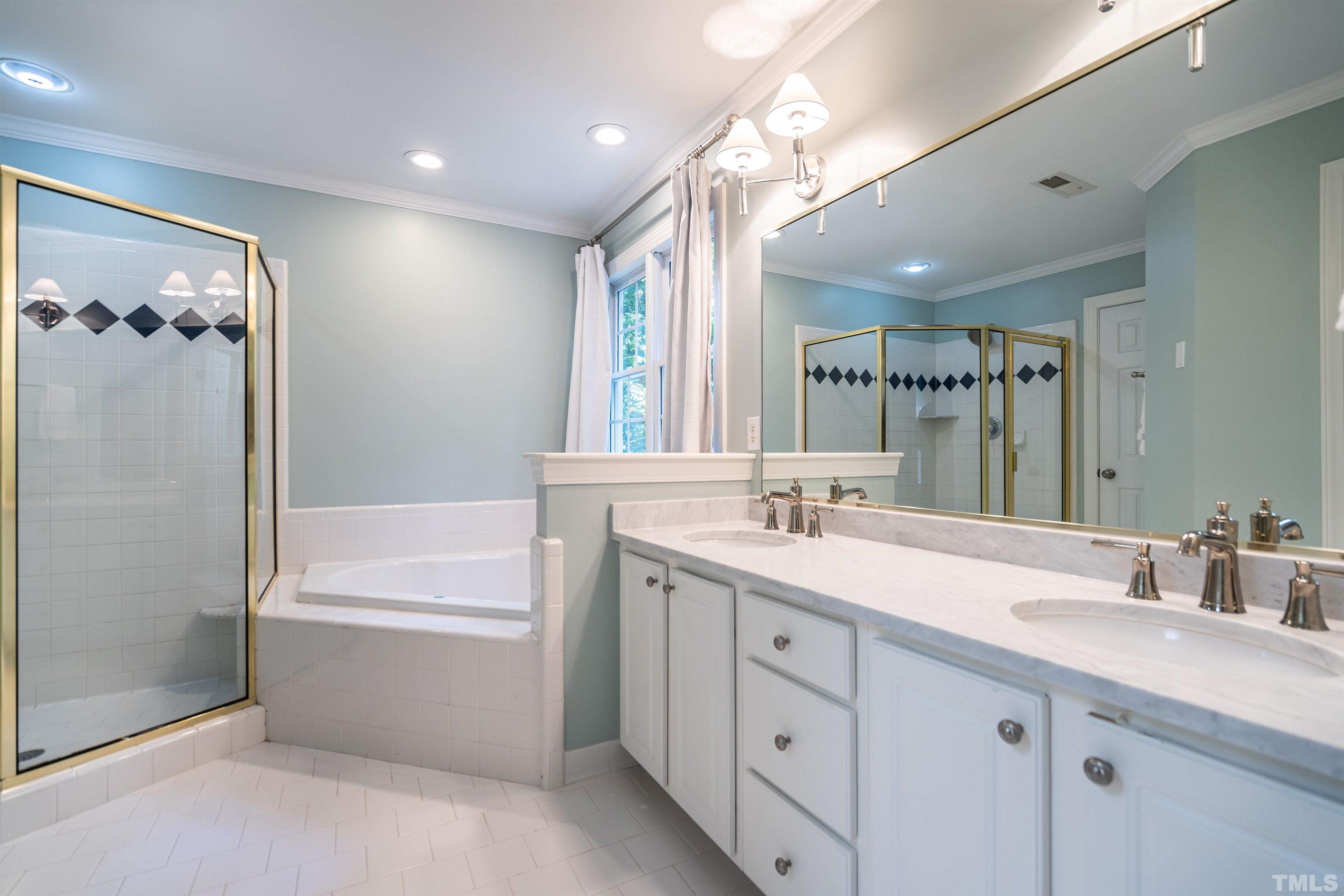 3016 Stone Gap Court Raleigh, NC 27612 - Photo 21 of 37 a bathroom with a tub a sink double vanity and a mirror