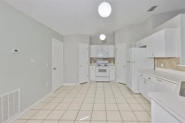 a kitchen with white cabinets appliances and a sink