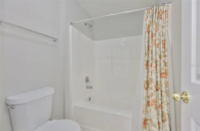 a bathroom with a shower curtain and a toilet