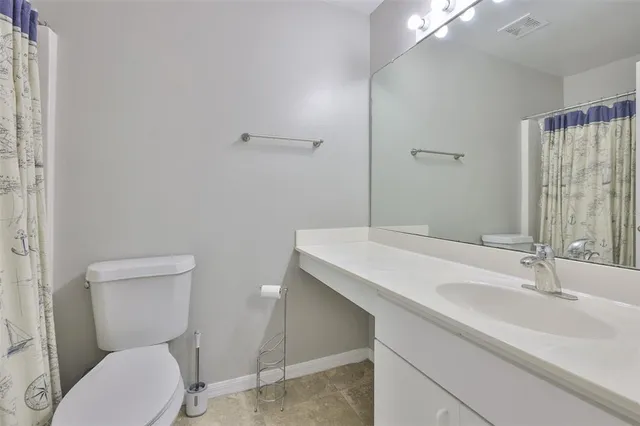 a bathroom with a sink a toilet a mirror and shower