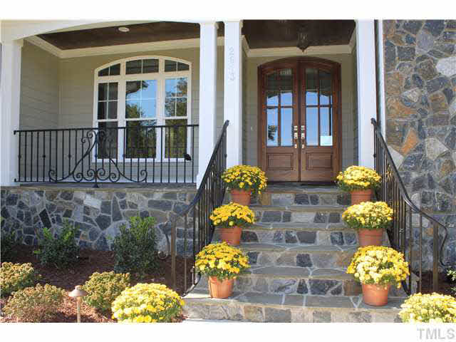 2613 Packhouse Road Zebulon, NC 27597 - Photo 5 of 25 Exquisite entrance genuine field stone stairs, porch and front wall accents, distinctive wrought iron handrails twin mahogany from door stained tounge and groove ceiling under porch.