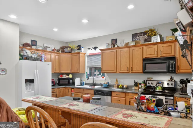 a open kitchen with stainless steel appliances granite countertop a refrigerator stove top oven a sink and dishwasher