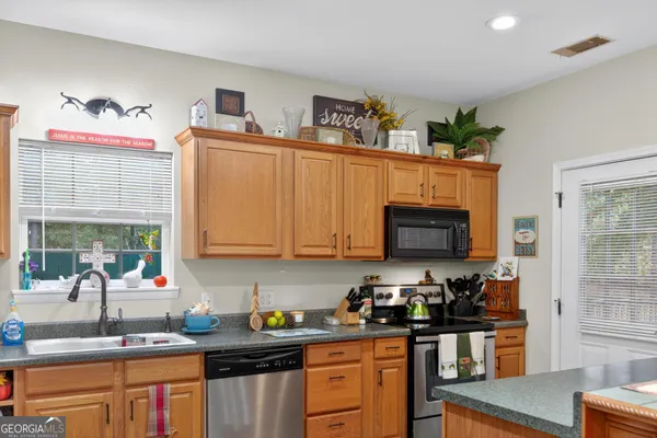 a kitchen with stainless steel appliances granite countertop a sink stove and cabinets