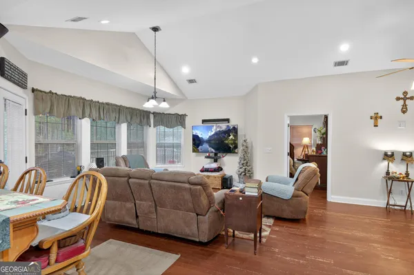 a living room with furniture a wooden floor and a chandelier