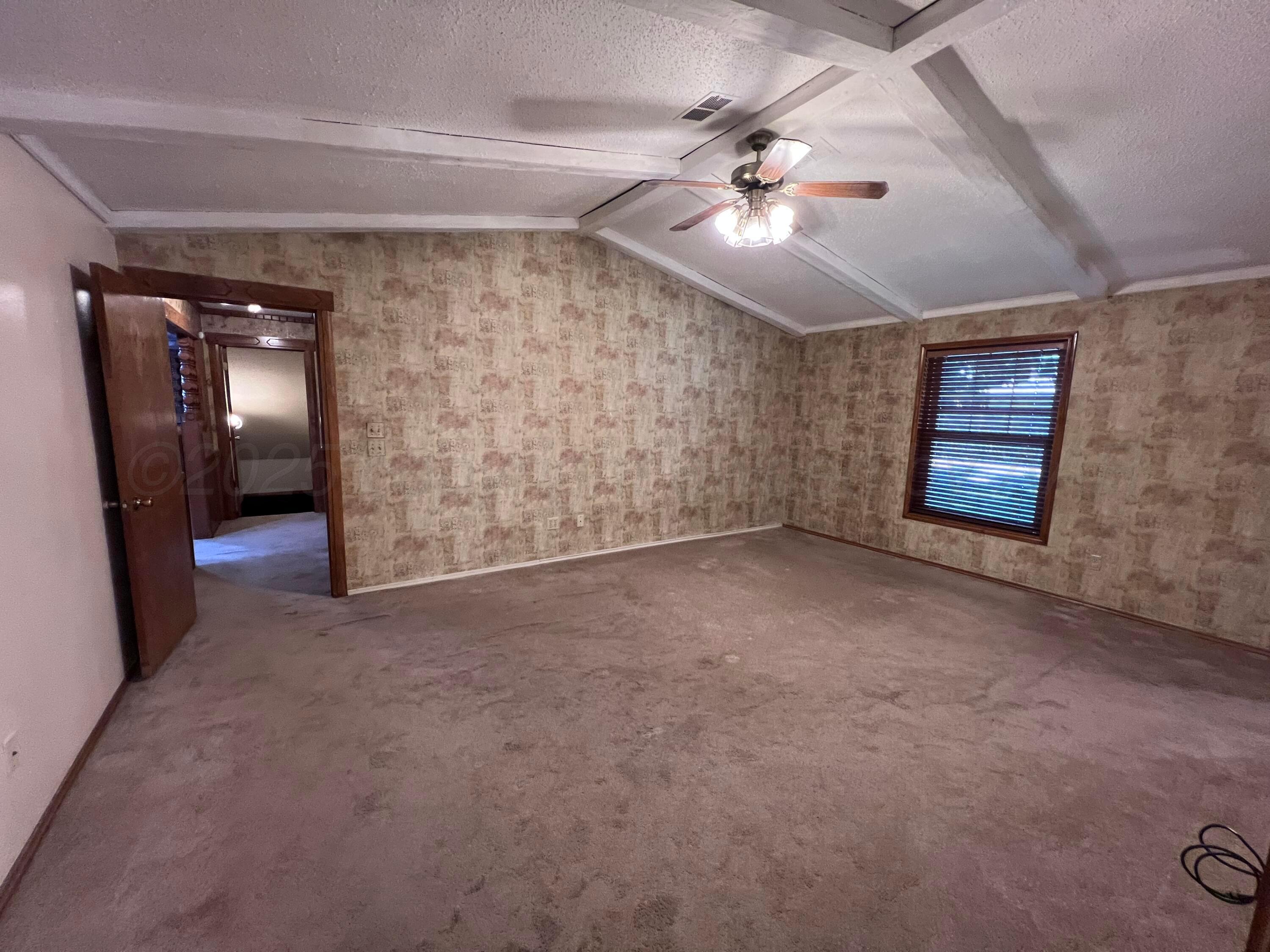 807 North Arrah Friona, TX 79035 - Photo 23 of 56 en empty room with windows and ceiling fan