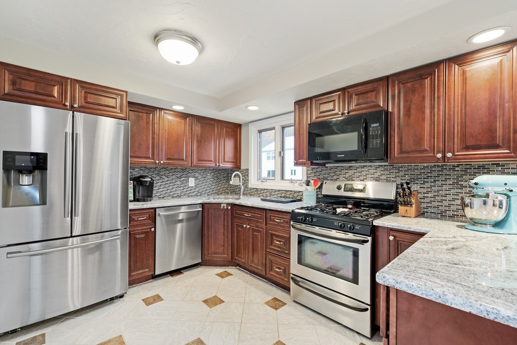 a kitchen with granite countertop appliances cabinets and a sink