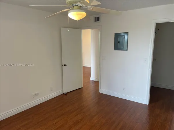a view of an empty room with wooden floor