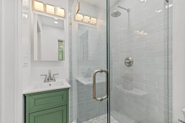 a bathroom with a shower a sink and mirror