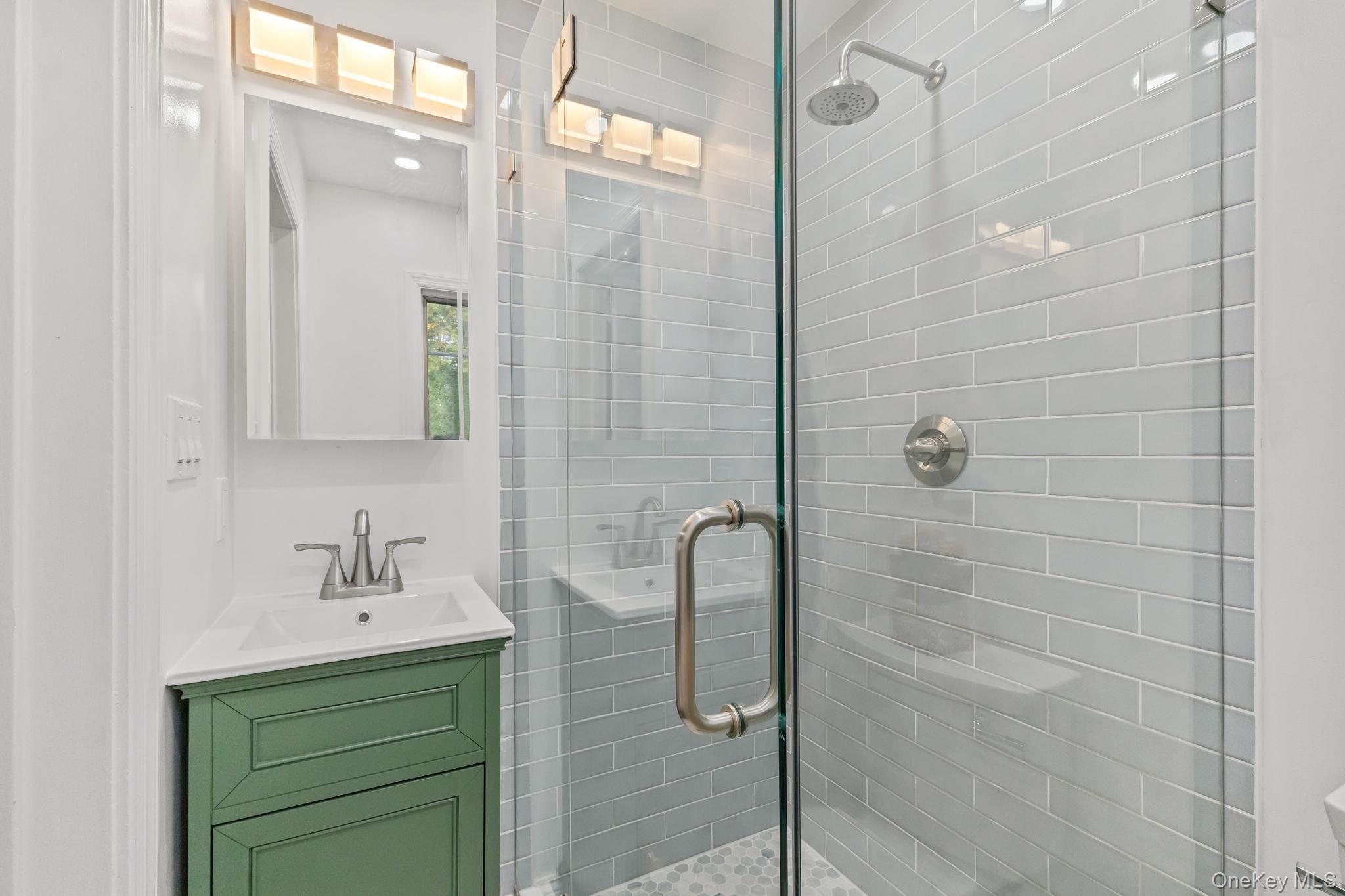 202 East Garden Road Larchmont, NY 10538 - Photo 11 of 35 a bathroom with a shower a sink and mirror