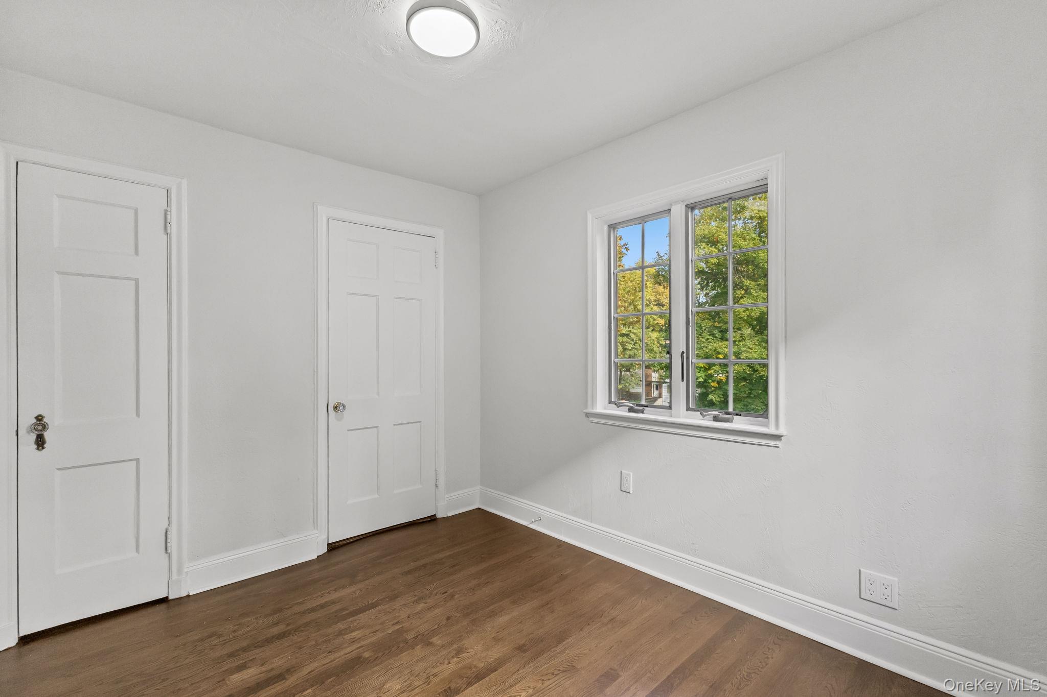 202 East Garden Road Larchmont, NY 10538 - Photo 13 of 35 a view of an empty room with wooden floor and a window