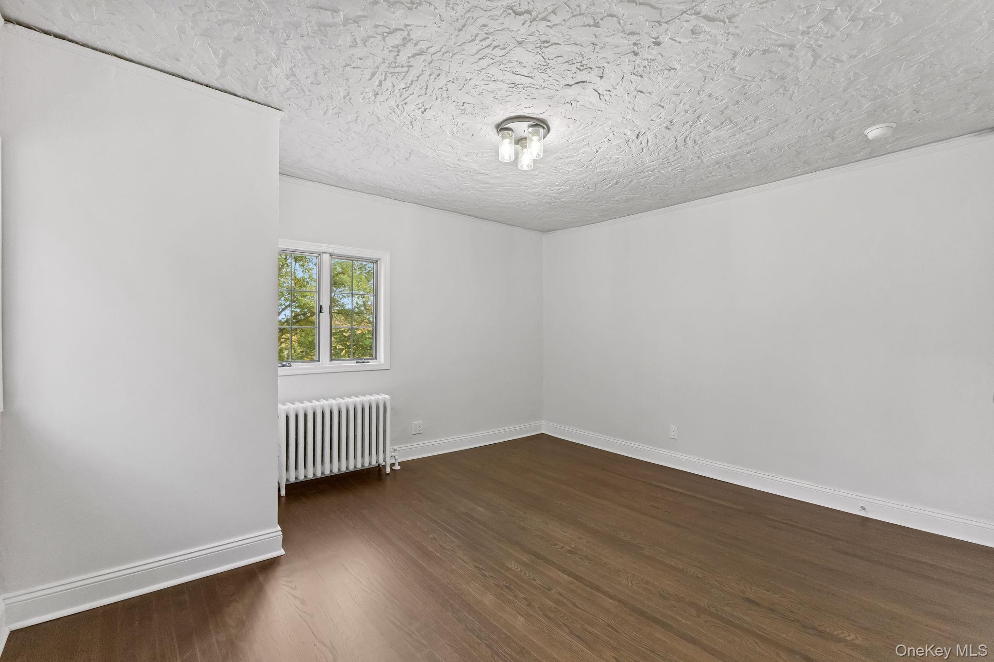 202 East Garden Road Larchmont, NY 10538 - Photo 25 of 35 an empty room with wooden floor and windows