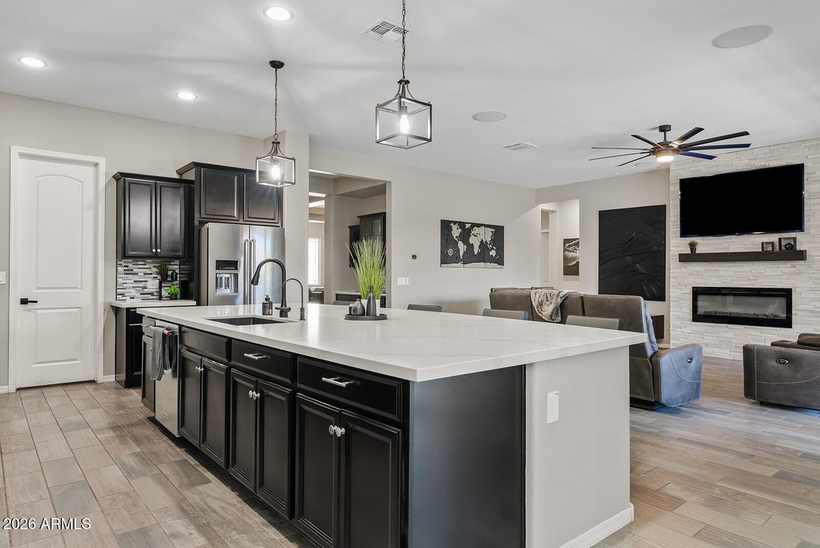 19411 East Timberline Road Queen Creek, AZ 85142 - Photo 19 of 44 a large kitchen with stainless steel appliances a stove center island a refrigerator wooden floor and a view of living room