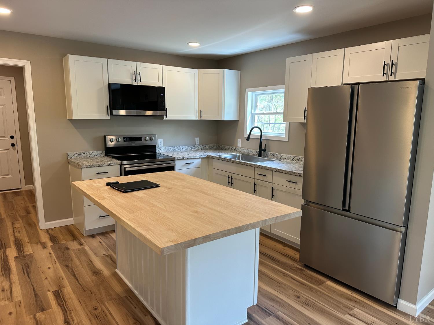 1221 Lynch Road Altavista, VA 24517 - Photo 3 of 14 a kitchen with a refrigerator a microwave a sink and cabinets