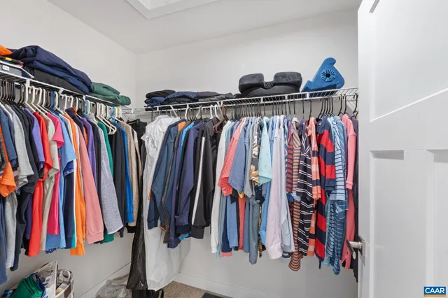 a view of walk in closet with clothes