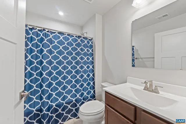 a bathroom with a sink a toilet a mirror and shower