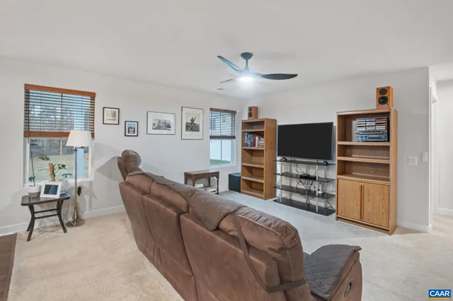 a living room with furniture a ceiling fan and a window