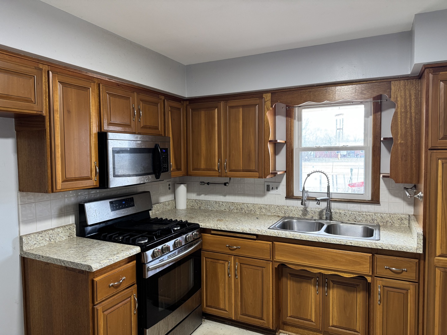 1988 South Bend Road Rockford, IL 61109 - Photo 3 of 26 a kitchen with granite countertop a stove a sink and a microwave