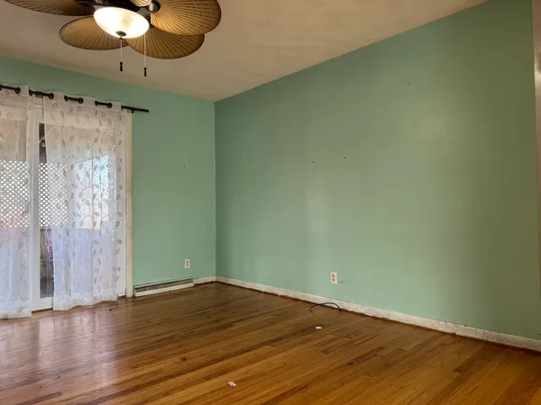 an empty room with wooden floor and windows