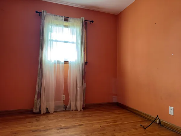 a view of a room with wooden floor and a window