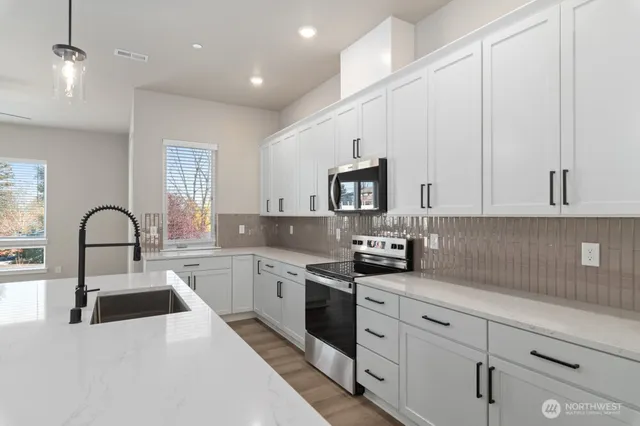 a kitchen with white cabinets a sink and appliances