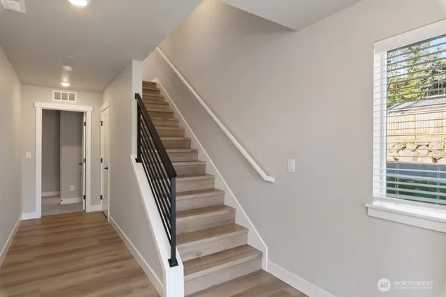 a view of a hallway with wooden floor and entryway