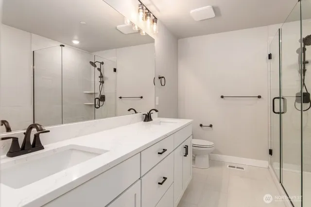 a bathroom with a sink a toilet and a large mirror