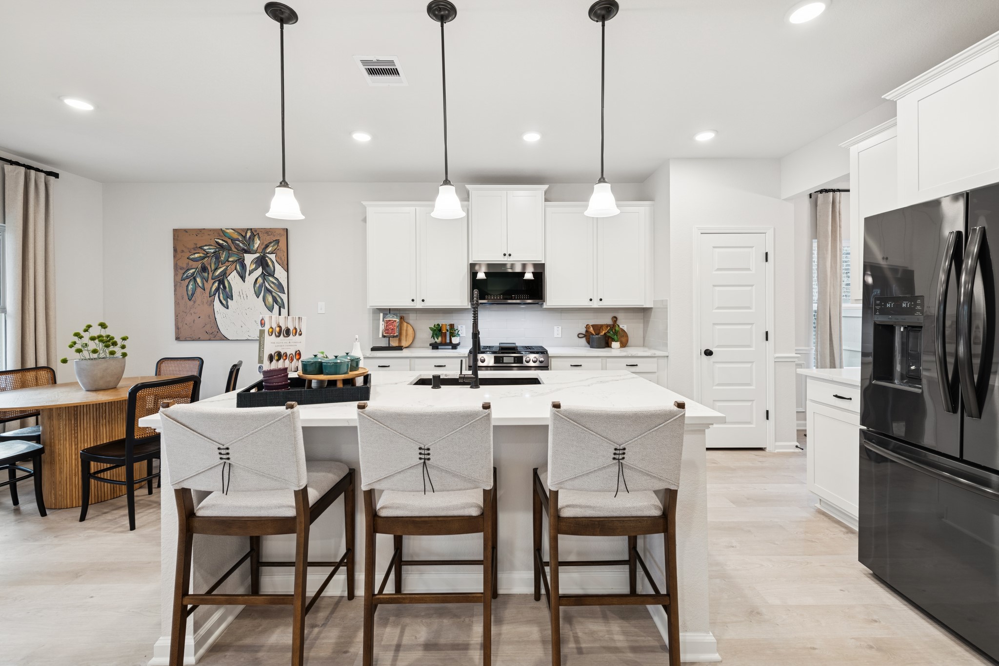 9726 Enclave Ridge Road Willis, TX 77318 - Photo 5 of 25 a kitchen with stainless steel appliances kitchen island a table chairs refrigerator and microwave