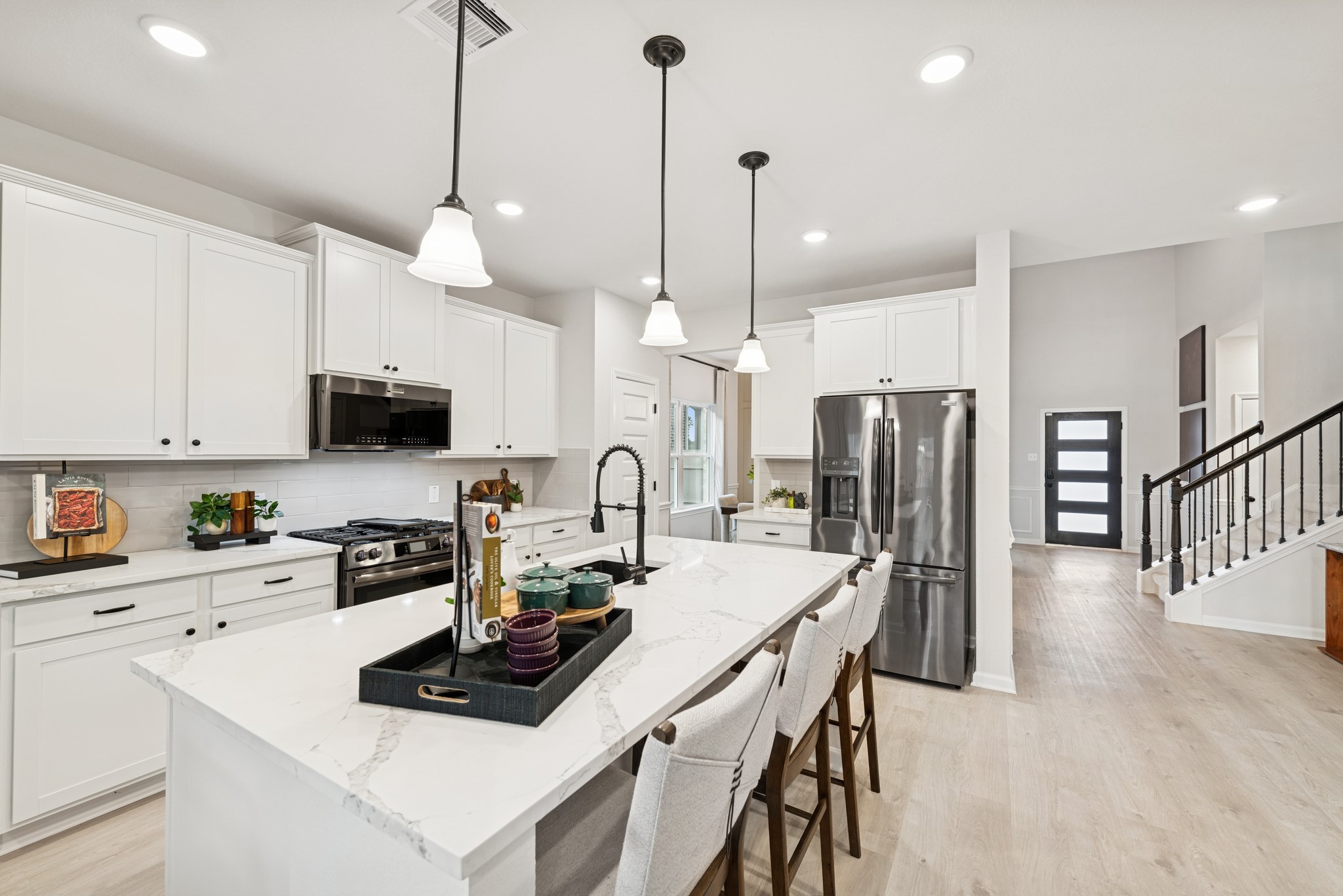 9726 Enclave Ridge Road Willis, TX 77318 - Photo 6 of 25 a kitchen with stainless steel appliances kitchen island granite countertop a stove a sink a refrigerator a center island a dining table and chairs