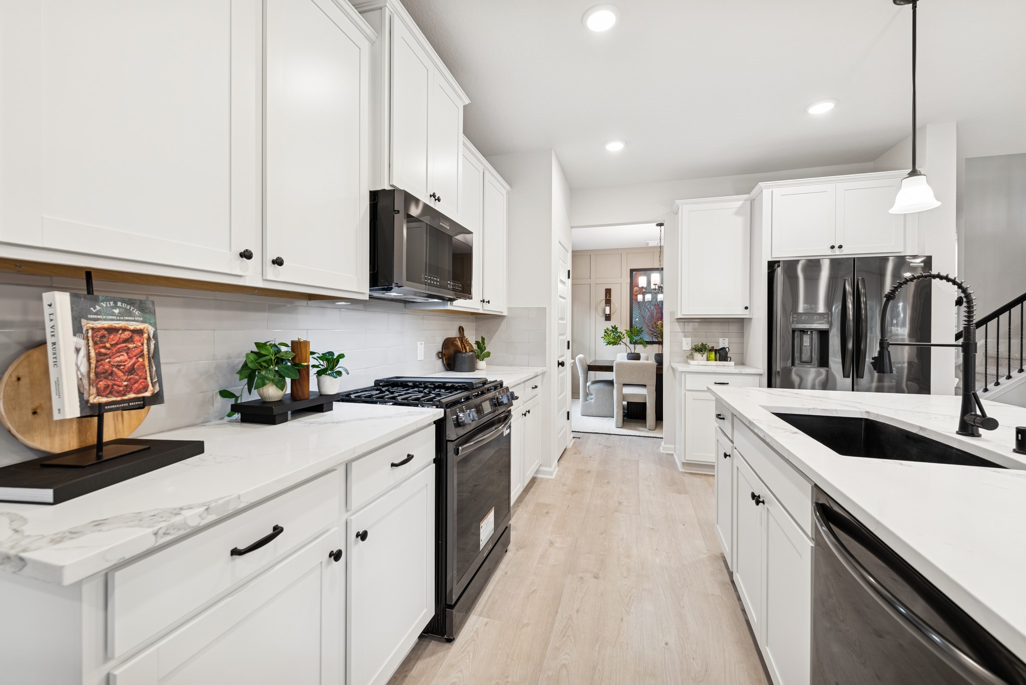 9726 Enclave Ridge Road Willis, TX 77318 - Photo 8 of 25 a large kitchen with stainless steel appliances granite countertop a lot of counter space and wooden floors