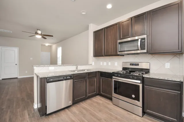 a kitchen with sink stove and microwave