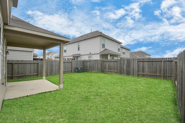 a view of a backyard with wooden fence