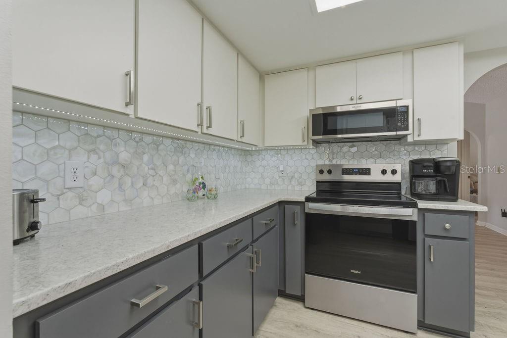 8873 Southwest 200th Circle Dunnellon, FL 34431 - Photo 16 of 61 a kitchen with stainless steel appliances granite countertop a sink a stove and microwave