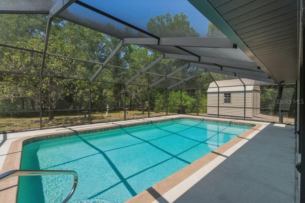 8873 Southwest 200th Circle Dunnellon, FL 34431 - Photo 2 of 61 a view of a backyard with table and chairs under an umbrella
