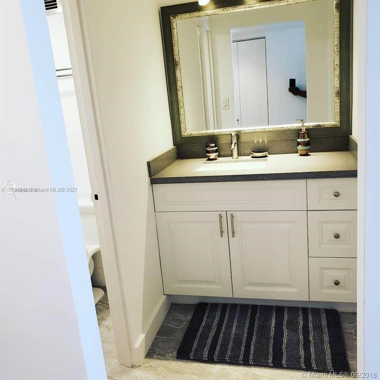 100 Lincoln Road, Unit 707 Miami Beach, FL 33139 - Photo 7 of 12 a bathroom with a sink a toilet and a mirror