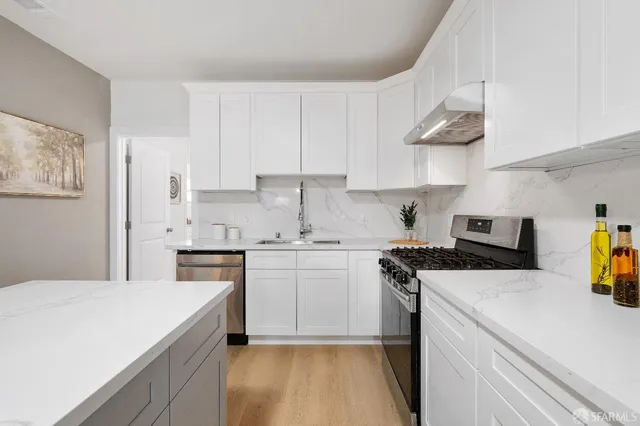 a kitchen with a sink a stove and cabinets