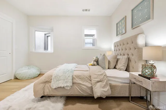 a bedroom with a bed and a lamp on dresser