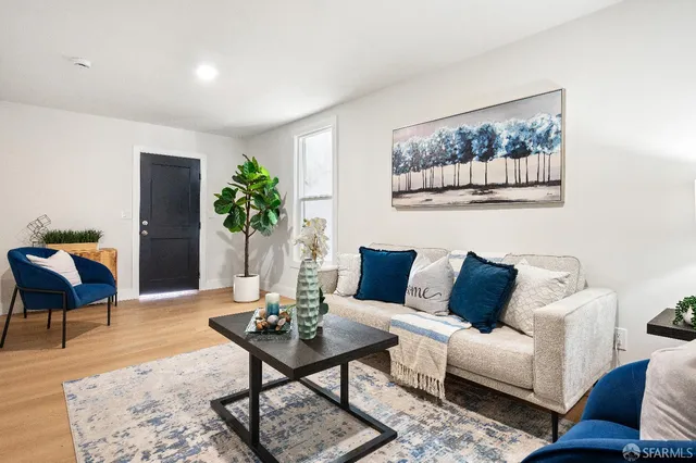 a living room with furniture potted plant and a table