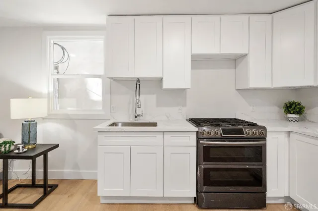 a kitchen with white cabinets and appliances